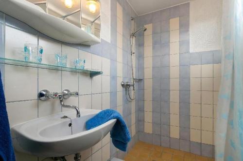 ParchtitzRügenHerz Fischerhütte的一间带水槽和蓝毛巾的浴室
