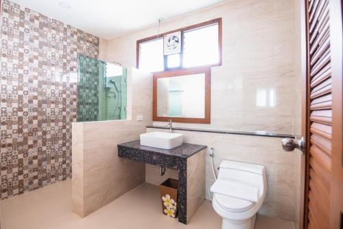 帕府Huen Him Kong Hotel Phrae的一间带卫生间、水槽和镜子的浴室