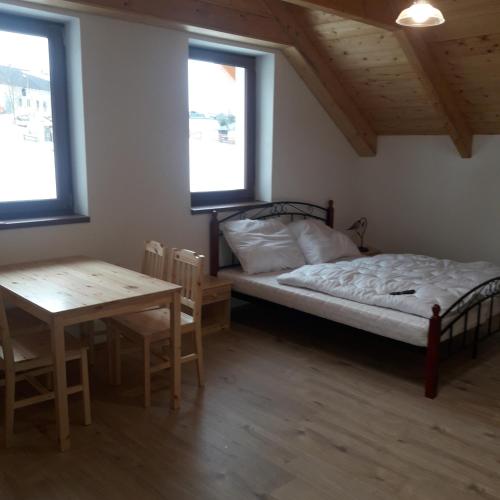 Jeřmaniceapartman u\Kapra的卧室配有床、桌子和窗户。