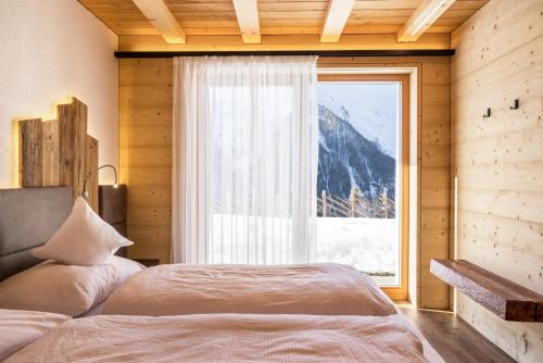 塞尔瓦德伊莫利尼Chalet Henne- Hochgruberhof的一间卧室设有一张床和一个大窗户