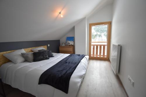 沃雅尼VAUJANYLOCATIONS - Le Chalet d Antoine et Mary的一间卧室设有一张大床和一个窗户。