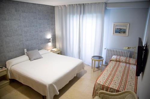 埃林雷纳维多利亚酒店的酒店客房,配有白色的床和椅子