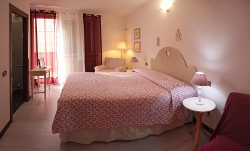 福洛尼卡Casa Margherita Affittacamere B&B的一间卧室配有一张大床和粉红色的床罩