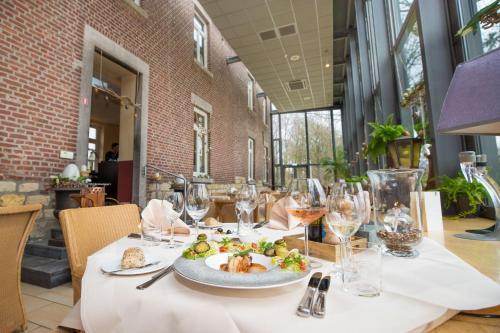 海尔伦Hotel de Rousch的一张桌子,上面放着一盘食物和酒杯