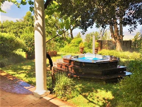 帕尔Bakenhof Winelands Lodge的坐在院子里的草上的一个热水浴缸