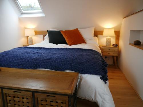 托特尼斯The Studio @ Bridge Cottage的一间卧室配有一张床、两盏灯和一个窗户。