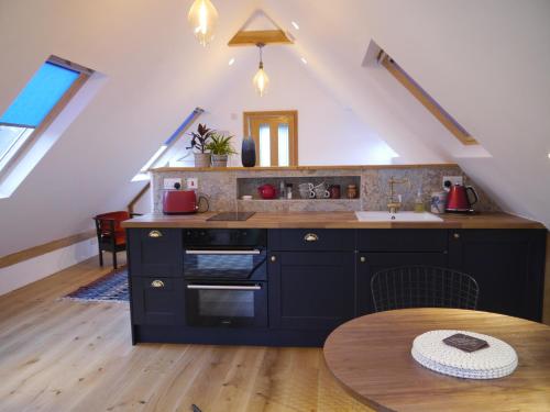 托特尼斯The Studio @ Bridge Cottage的厨房配有炉灶、水槽和桌子