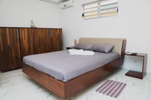 WanicaLiberdada Villa SURINAME的一间卧室配有一张大床和木柜