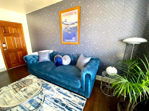 俄克拉何马城Bright OKC Midtown Studio-Coolest neighborhood的客厅设有一张蓝色的沙发,客厅设有一面墙