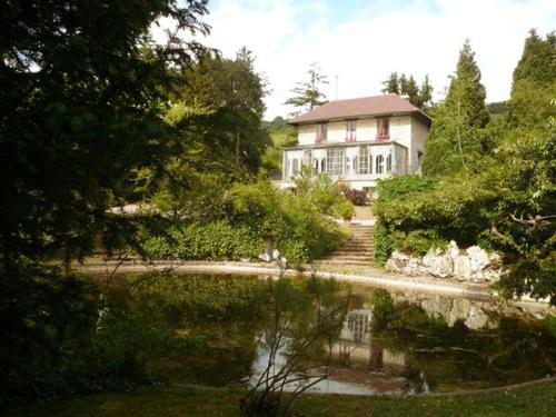 吉维尼勒普伊玫瑰酒店的房屋前有池塘的房子