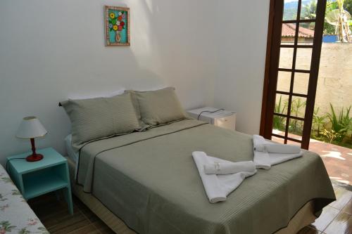 帕拉蒂Pouso Paratiense Jabaquara的一间卧室配有一张床,上面有两条毛巾