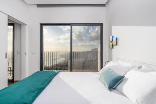 丰沙尔Relax View的卧室配有白色的床和大窗户