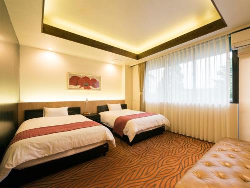 金泽兼六坂酒店的酒店客房设有两张床和窗户。