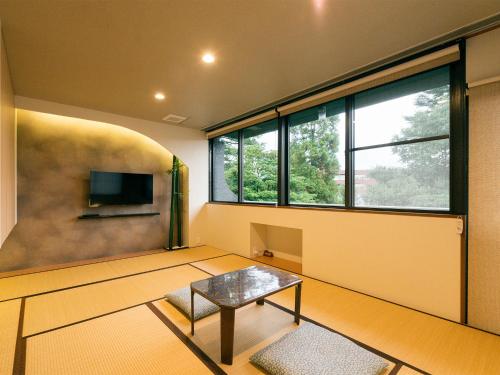 金泽兼六坂酒店的客厅配有桌子和电视
