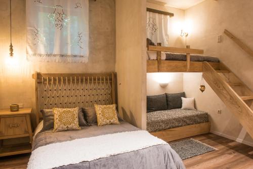 Magoúliana«Σκλάβας Χνάρι» Παραδοσιακός Ξενώνας的一间卧室配有一张床和两张双层床。