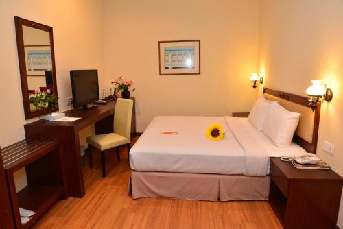马六甲Cheng Ho Hotel的酒店客房配有一张床、一张书桌和一台电脑