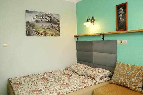 涅兹卡城堡Pokoje Gościnne的一间设有一张床的客房,墙上挂着一张照片
