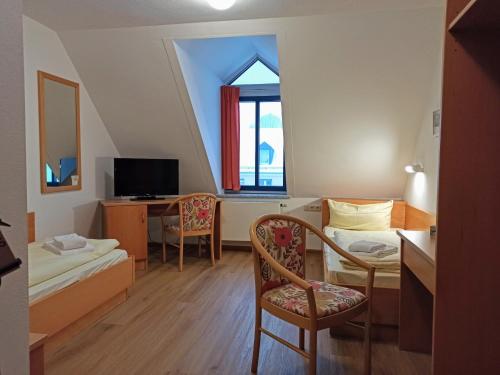 德根多夫Stadthotel Deggendorf的小房间设有床、书桌和窗户