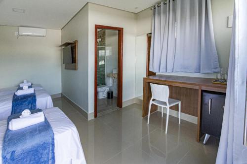 戈亚斯州上帕莱索Villa Tereza的酒店客房带两张床和一间浴室