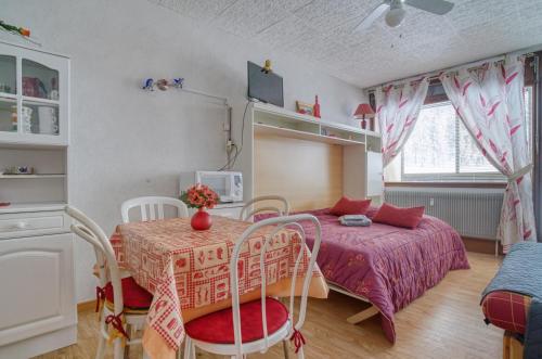 拉布雷斯Les Cimes de Belle Hutte的卧室配有一张床和一张桌子及椅子