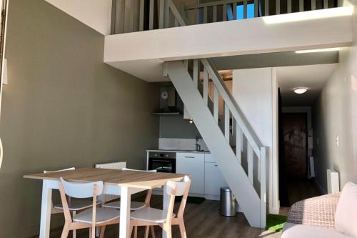 普洛埃默Magnifique duplex super cosy Vue mer 180的一间带桌椅和楼梯的用餐室