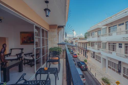 圣多明各Hotel La Colonia的公寓的阳台配有椅子,享有街道的景致。