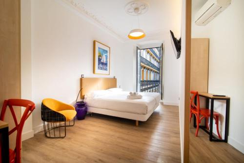 圣塞瓦斯蒂安Central Roomss的酒店客房带一张床、一张桌子和椅子