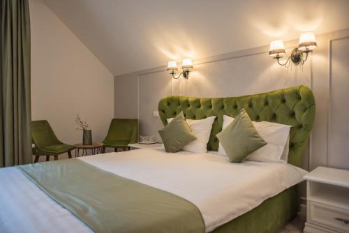 锡纳亚Boga Rooms的一间卧室配有一张大床和绿色床头板