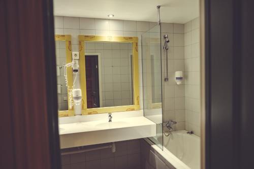 科威费耶尔古德布兰得斯加德酒店的浴室配有盥洗盆、镜子和浴缸