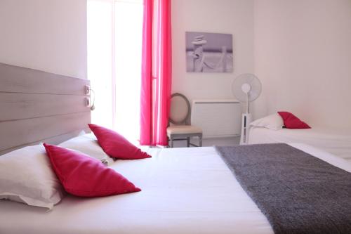 迈兹Hotel-Restaurant Du Port的一间卧室配有两张带红白色枕头的床
