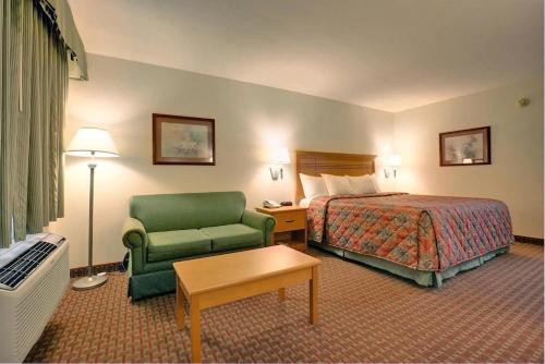 迪索托Scottish Inns的酒店客房,配有一张床和一把绿色椅子