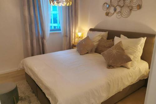 斯特拉斯堡Magnifique F3, 75m² avec Parking privé et Terrasse的卧室内的一张带白色床单和枕头的床