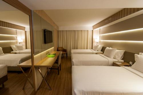 里约热内卢美洲科帕卡巴纳酒店 的酒店客房设有三张床和一张书桌