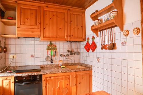 法尔西德TRE CIME FOCOBON - Bellavista sulle Dolomiti的一个带木制橱柜和水槽的厨房