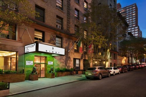 纽约Night Hotel Broadway的一条在大楼前停放汽车的街道
