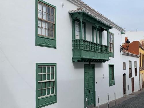 圣克鲁斯-德拉帕尔马Casa Emblemática Don Gabriel的白色的建筑,设有绿色的窗户和阳台