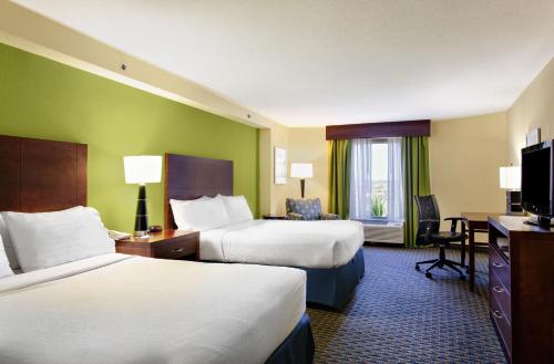 代托纳海滩代托纳海滩假日酒店及套房的酒店客房配有两张床和一张书桌