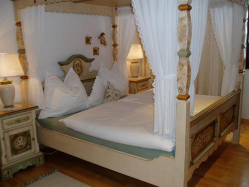 帕特加森Leebhof的卧室配有带白色床单和枕头的天蓬床。