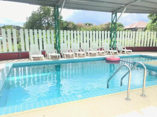 清迈伊甸花园度假酒店的一个带椅子和围栏的游泳池