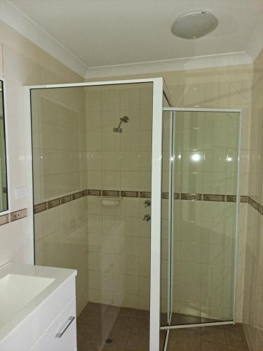 卡尔古利阿尔比欧酒店的一间带玻璃淋浴和水槽的浴室