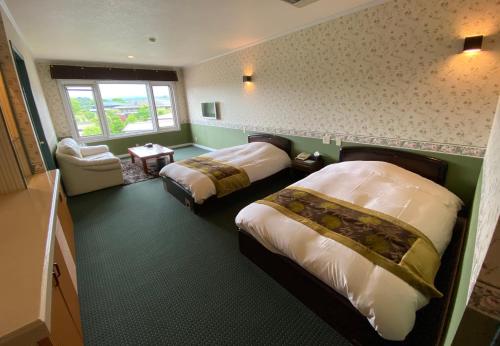 富士河口湖Auberge Mermaid的酒店客房设有两张床和窗户。