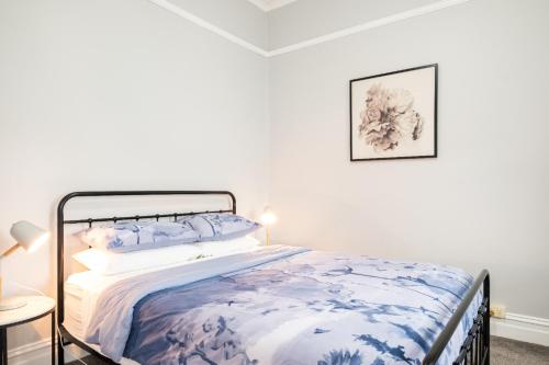 吉朗Quartz Cottage Geelong的一间卧室配有一张带蓝色和白色棉被的床