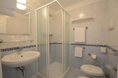 佩萨罗Hotel Caravelle的带淋浴、盥洗盆和卫生间的浴室