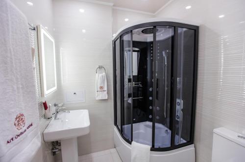塔什干Art Deluxe Hotel的带淋浴和盥洗盆的白色浴室
