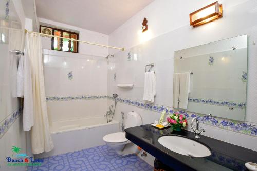 可瓦兰Beach and Lake Ayurvedic Resort, Kovalam的浴室配有盥洗盆、卫生间和浴缸。