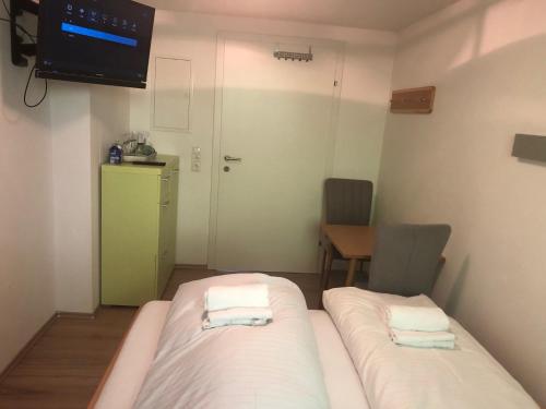 滨湖采尔Schmitten Haus的小房间设有两张床和电视