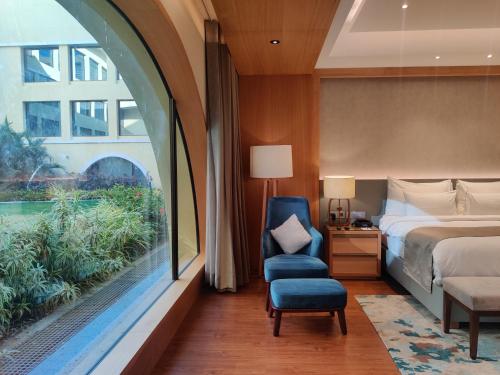 AdalajBelvedere Golf & Country Club的卧室配有床、椅子和窗户。