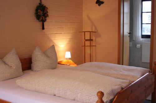 KüstenLandhotel Belitz Garni的一张带白色床单和枕头的床