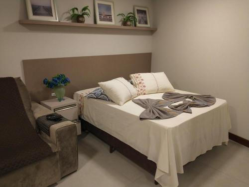 拉古纳Residence Farol - Loft 219的一间卧室配有一张床和一把椅子