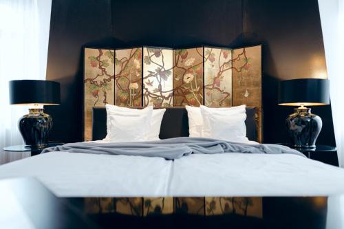 班贝格班贝格霍夫贝尔维尤酒店的一间卧室配有一张大床和两盏灯